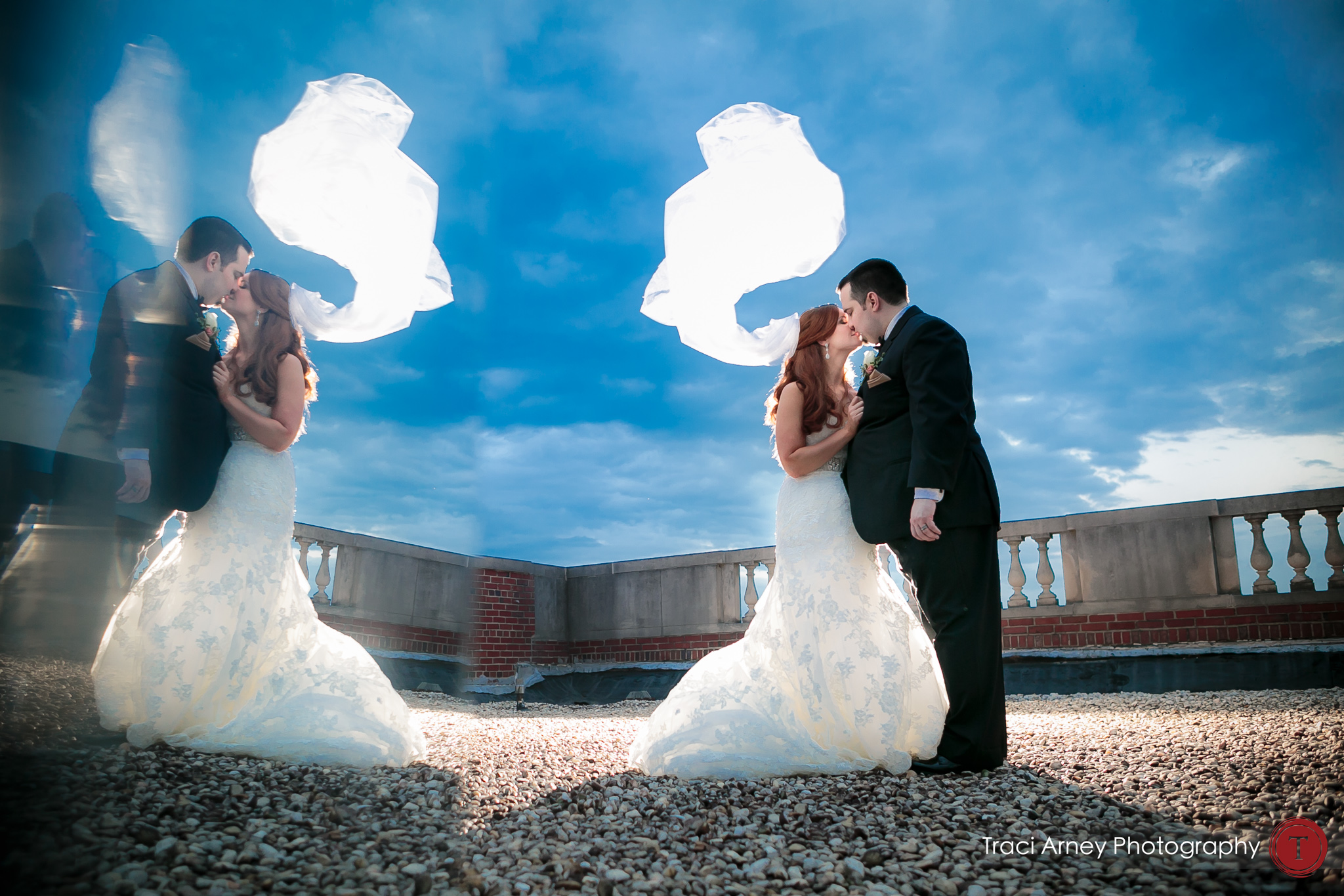 Mirrored bride and groom with backlit veil and blue skies at their wedding at Millennium Center in Winston-Salem, NC.